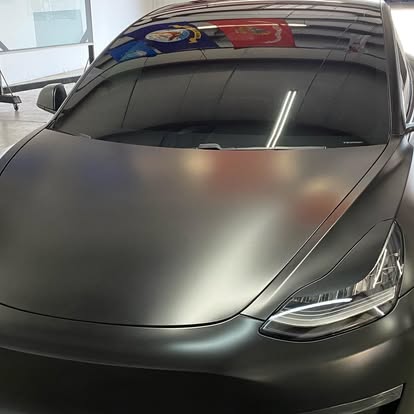 Custom matte black vinyl wrap on a Tesla